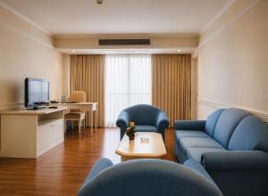 a living room with a couch and a table at The Palazzo Hotel in Bangkok