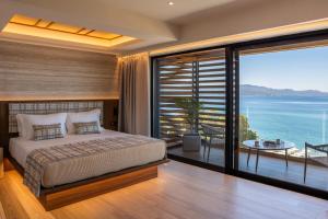 a bedroom with a bed and a view of the ocean at TAYS Hotel in Kalamata