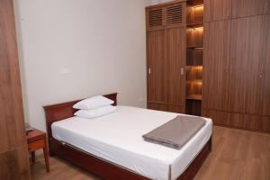 a bedroom with a bed and wooden cabinets at Nhà Khách TW in Hanoi