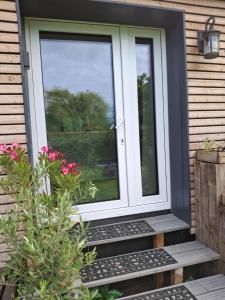 a front door of a house with flowers at Moordiele in Kröpelin