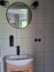 a bathroom with a white sink and a mirror at Moordiele in Kröpelin
