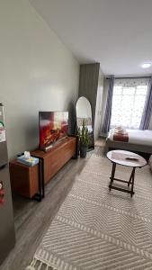 a living room with a tv and a couch at Amber Home Ruaka Near Two Rivers Mall & UN in Ruaka