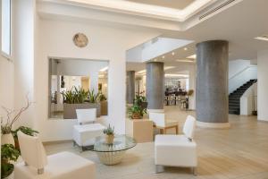 a lobby with white chairs and a table at Occidental Aurelia in Rome