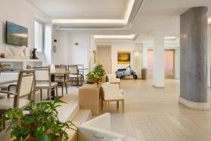 a lobby with tables and chairs and a scooter at Occidental Aurelia in Rome