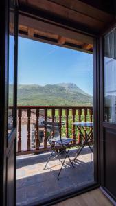 a balcony with a table and a view of a mountain at Posada VALLE DEL ASON in Ogarrio