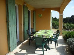 - une table et des chaises sur la terrasse couverte d'une maison dans l'établissement Villa Pays d'Oc, à Béziers