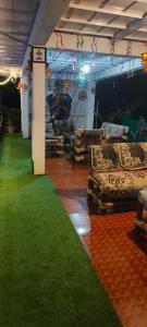 a room with green carpet and chairs in it at ChangGhor in Digru