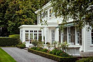 a white house with a bench in front of it at Fernside Estate and Gardens in Fernside