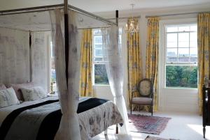 a bedroom with a canopy bed with yellow curtains at Fernside Estate and Gardens in Fernside