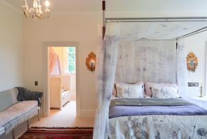 a bedroom with a canopy bed and a chandelier at Fernside Estate and Gardens in Fernside