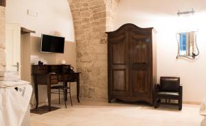 a room with a wooden door and a desk at Le Dimore del Finoglio in Conversano