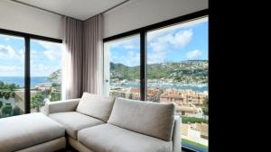 a living room with a white couch and large windows at The One in Port d'Andratx