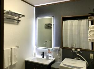 a bathroom with a sink and a mirror and a toilet at 北軽井沢 SPAHA Karuizawa Forest Resort Villa YB1 in Kita-karuizawa