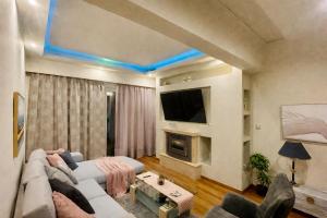 a living room with a couch and a tv at Seafront Central Luxury Apartment in Samos