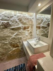 a bathroom with a sink and a stone wall at Seafront Central Luxury Apartment in Samos +45 photos