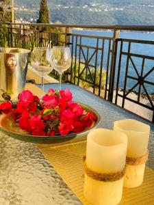a table with a plate of flowers and wine glasses at Seafront Central Luxury Apartment in Samos