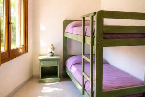 a bunk bed room with two bunk beds with purple sheets at Hotiday Orosei Fuile e Mare in Orosei