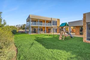 a house with a yard with a playground at Ultimate Ocean Views - Pet Friendly in Bellbrae
