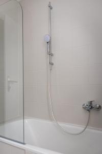 a shower with a glass door next to a tub at Apartment Camping Melk in Melk