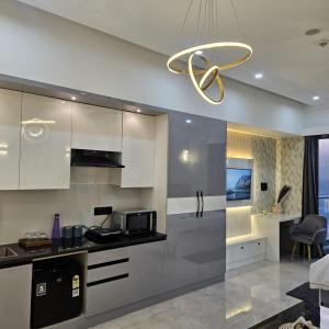 a kitchen with white cabinets and a chandelier at Galaxy blue sapphire studio in Ghaziabad