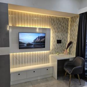 a living room with a television on a wall at Galaxy blue sapphire studio in Ghaziabad