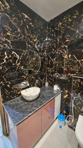 a bathroom with a black and gold marble wall at Galaxy blue sapphire studio in Ghaziabad +14 photos