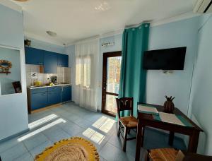 a kitchen with blue cabinets and a table and a dining room at Sun Thavma Living studio psiloritis in Lístaros