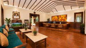 a living room with a couch and a bar at Avana Resort in Mettuppālaiyam
