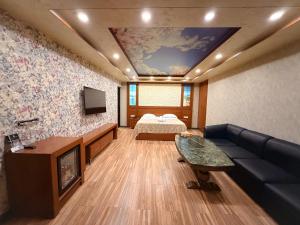 a living room with a couch and a bed at Israel Ori Hotel in Yerevan