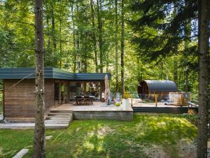 a house in the woods with a deck at GOZDNE VILE va VRTI in Kostel