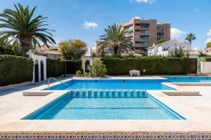 a swimming pool in a villa with palm trees at Chalet Mayor Zenia Beach in Orihuela