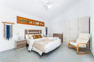 a bedroom with a bed and a chair at Chalet Mayor Zenia Beach in Orihuela +19 photos