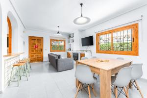 a kitchen and living room with a wooden table and chairs at Chalet Mayor Zenia Beach in Orihuela