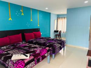 a bedroom with two beds and a blue wall at SB Cottage ooty in Ooty