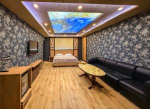 a room with a bed and a couch and a tv at Israel Ori Hotel in Yerevan