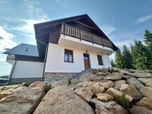 a house on top of a pile of rocks at Pod Lovčí skálou in Modrava