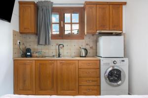 a kitchen with wooden cabinets and a washing machine at Dionysus House in Magoulás