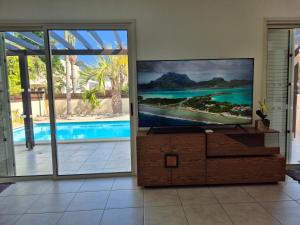 a living room with a flat screen tv on a dresser at Villa Larnaca Bay Resort in Oroklini