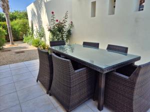 a dining table and chairs with a glass top at Villa Larnaca Bay Resort in Oroklini