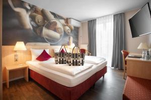 a hotel room with a bed with a large painting on the wall at Hotel Halfenstube & Villa Spa 1894 in Senheim +73 photos