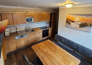 a kitchen with wooden cabinets and a wooden coffee table at Haus Seelter Gluk in Bollingen