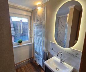 a bathroom with a sink and a mirror and a window at Haus Seelter Gluk in Bollingen