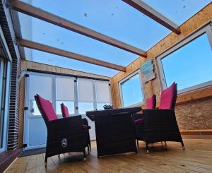 a dining room with pink chairs and a table at Haus Seelter Gluk in Bollingen