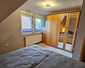 a bedroom with a bed and some windows at Haus Seelter Gluk in Bollingen