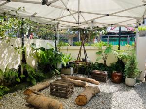 a garden with logs laying on the ground under a tent at Outdo'r Garden House in Tuy Hoa