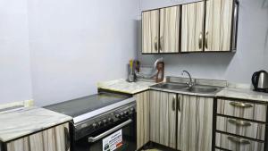 a kitchen with wooden cabinets and a sink at ركن دار الطائف in Taif