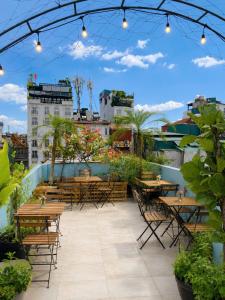 a patio with tables and chairs on a roof at Awesome Hanoi Hostel & Travel in Hanoi