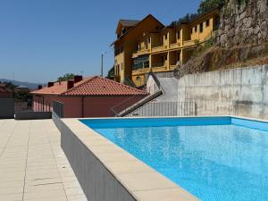 a swimming pool in front of a building at Gerês River Terrace in Geres
