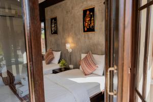 a small room with two beds and a window at Thanawong Pool Villa in Sukhothai