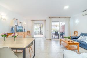 a living room with a table and a blue couch at Jouvacations Villa 3 Freser con piscina compartida in Empuriabrava